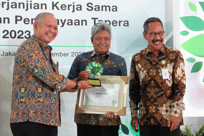 Direktur Consumer Bank BTN Hirwandi Gafar (kedua kanan) menunjukkan naskah perjanjian kerja sama penyaluran KPR Sejahtera FLPP dan Pembiayaan Tapera.