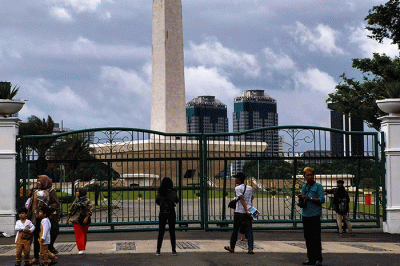 Pengunjung tetap datang berlibur ke kawasan Monas dari luar walaupun peringatan cuaca hujan disertai angin melanda Jakarta, Rabu (28/12/2022).