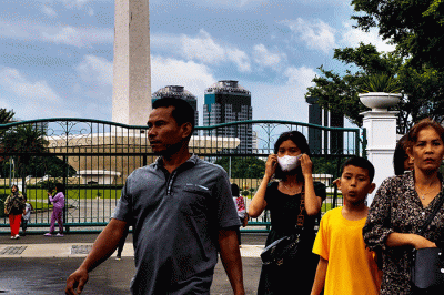 Pengunjung tetap datang berlibur ke kawasan Monas dari luar walaupun peringatan cuaca hujan disertai angin melanda Jakarta, Rabu (28/12/2022).
