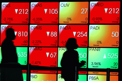 Karyawan melintasi layar yang menampilkan Indeks Harga Saham Gabungan (IHSG) saat acara Penutupan Perdagangan Bursa Efek Indonesia Tahun 2022 di Jakarta.