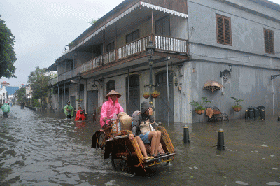 Sejumlah warga menerjang banjir yang merendam kawasan Kota Lama Semarang, Jawa Tengah, Sabtu (31/12/2022).