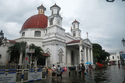 Sejumlah warga menerjang banjir yang merendam kawasan Kota Lama Semarang, Jawa Tengah, Sabtu (31/12/2022).