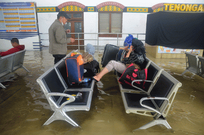 Aktivitas penumpang di Stasiun Semarang Tawang di tengah genangan banjir, Sabtu (31/12/2022).