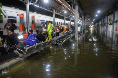 Aktivitas penumpang di Stasiun Semarang Tawang di tengah genangan banjir, Sabtu (31/12/2022).