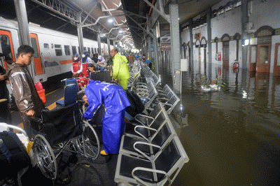 Aktivitas penumpang di Stasiun Semarang Tawang di tengah genangan banjir, Sabtu (31/12/2022).