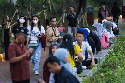 Pengunjung beraktivitas saat berwisata di Taman Mini Indonesia Indah (TMII), Jakarta Timur, Sabtu (31/12/2022).