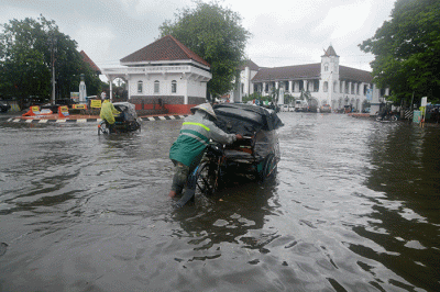 Sejumlah warga harus berjibaku menerjang banjir di kawasan titik nol (KM 0) Semarang, Jawa Tengah, Sabtu (31/12/2022).