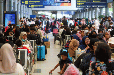Para penumpang kereta api mengalami penundaan keberangkatan sehingga terjadi penumpukan di Stasiun Pasar Senen, Jakarta, Minggu (1/1/2023).