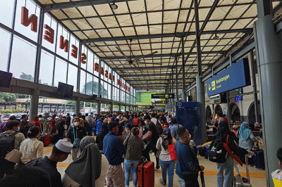 Para penumpang kereta api mengalami penundaan keberangkatan sehingga terjadi penumpukan di Stasiun Pasar Senen, Jakarta, Minggu (1/1/2023).