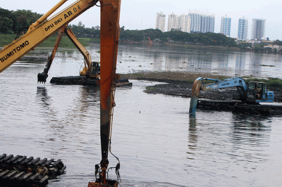Petugas Suku Dinas Sumber Daya Air mengunakan Alat berat melakukan pengerukan Waduk Pluit, Penjaringan, Jakarta Utara, Selasa (3/1/2023).