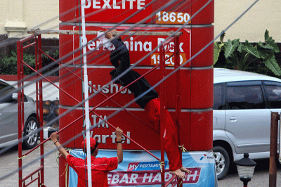 Petugas SPBU 24.301.118 Jalan Jenderal Sudirman KM 3,5 Palembang menganti daftar harga Bahan Bakar (BBM) non subsidi yang mengalami penurunan.