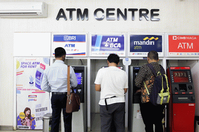 Nasabah melakukan transaksi di Anjungan Tunai Mandiri (ATM) kawasan Jakarta Selatan, Senin (9/1/2023).