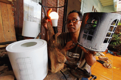 Perajin menyelesaikan pembuatan lampu hias dengan berbahan baku sampah plastik atau plastik tempat cat juga limbah kayu di kawasan Pamulang, Tangerang Selatan.
