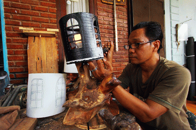 Perajin menyelesaikan pembuatan lampu hias dengan berbahan baku sampah plastik atau plastik tempat cat juga limbah kayu di kawasan Pamulang, Tangerang Selatan.