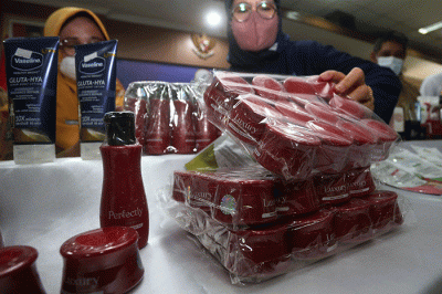 Kepala Balai Besar POM Surabaya Rustyawati (tengah) menunjukkan sampling berbagai jenis produk kosmetik dan pangan ilegal di kantor Balai Besar POM di Surabaya.