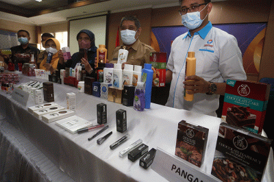 Kepala Balai Besar POM Surabaya Rustyawati (tengah) menunjukkan sampling berbagai jenis produk kosmetik dan pangan ilegal di kantor Balai Besar POM di Surabaya.