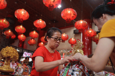 Warga keturunan Tionghoa membersihkan patung dewa di Kelenteng Xian Ma, Makassar, Senin (16/1/2023).