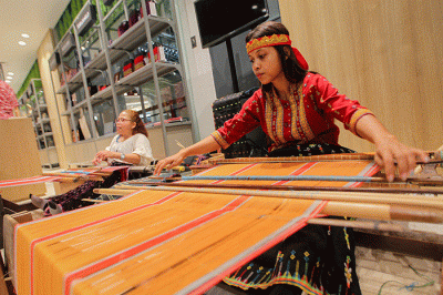 Pengerajin asal Kabupaten Manggarai Nusa Tenggara Timur (NTT) saat menyelesaikan pembuatan kain tenun di Mal Sarinah, Jakarta, Senin (23/1/2023).
