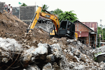 Warga dan petugas melakukan pembersihan, termasuk puing-puing sisa material bangunan yang rusak akibat tanah longsor di Kota Manado.