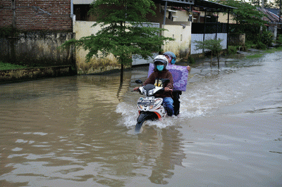 Pengendara nekat menerobos banjir di Jalan Kecaping Raya, Perumnas Antang Blok 10, Makassar, Selasa (31/1/2023).