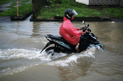 Pengendara nekat menerobos banjir di Jalan Kecaping Raya, Perumnas Antang Blok 10, Makassar, Selasa (31/1/2023).