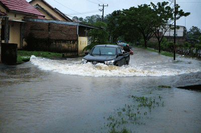 Pengendara nekat menerobos banjir di Jalan Kecaping Raya, Perumnas Antang Blok 10, Makassar, Selasa (31/1/2023).