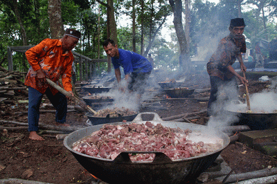 Puluhan warga bergotong royong memasak daging kambing untuk dibagikan ke peziarah dalam tradisi Nyadran di kompleks Pemakaman Umum Sentono.