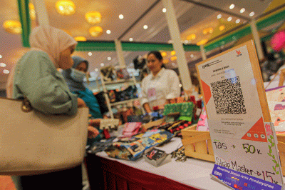 Pembeli membayar menggunakan QRIS dalam acara pameran UMKM di Jakarta, Jumat (3/2/2023).