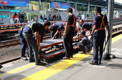 Sejumlah pekerja memasang tangga untuk pengguna KRL di Stasiun Tebet, Jakarta Selatan, Senin (6/2/2023).