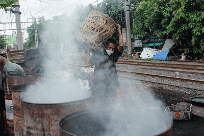Pekerja membuat arang dari bahan batok kelapa di kawasan Jakarta Pusat, Rabu (8/2/2023).