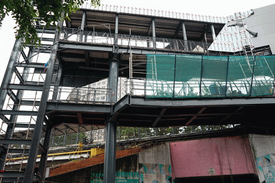 Pekerja menyelesaikan jembatan penghubung Stasiun Cawang ke halte Transjakarta, Selasa (7/2/2023).