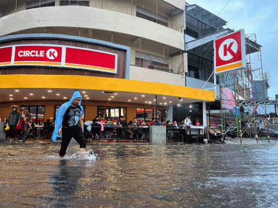 Sejumlah pengendara menerobos banjir yang menutupi jalan protokol pusat Kota Makassar, Senin (13/2/2023).