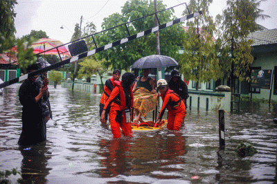 Sejumlah pengendara menerobos banjir yang menutupi jalan protokol pusat Kota Makassar, Senin (13/2/2023).