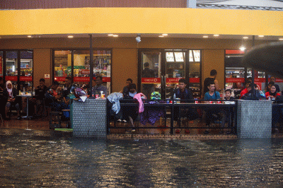 Sejumlah pengendara menerobos banjir yang menutupi jalan protokol pusat Kota Makassar, Senin (13/2/2023).