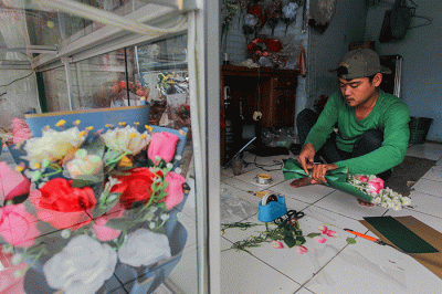 Penjual bunga saat membuat pesanan bucket mawar di Jalan Raya Pondok Gede, Jakarta Timur, Selasa (14/2/2023).