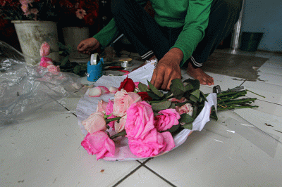 Penjual bunga saat membuat pesanan bucket mawar di Jalan Raya Pondok Gede, Jakarta Timur, Selasa (14/2/2023).