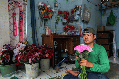 Penjual bunga saat membuat pesanan bucket mawar di Jalan Raya Pondok Gede, Jakarta Timur, Selasa (14/2/2023).