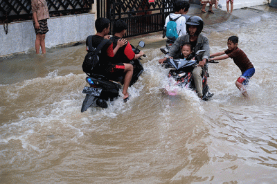 Sejumlah anak-anak bermain di tengah banjir di kawasan Jalan Nipa-nipa, Makassar, Kamis (15/2/2023).