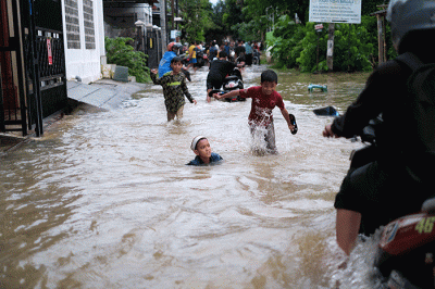 Sejumlah anak-anak bermain di tengah banjir di kawasan Jalan Nipa-nipa, Makassar, Kamis (15/2/2023).