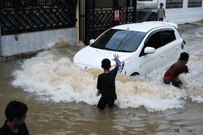 Sejumlah anak-anak bermain di tengah banjir di kawasan Jalan Nipa-nipa, Makassar, Kamis (15/2/2023).