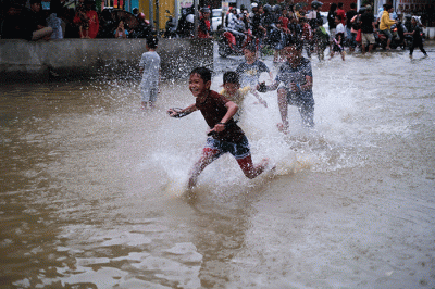 Sejumlah anak-anak bermain di tengah banjir di kawasan Jalan Nipa-nipa, Makassar, Kamis (15/2/2023).