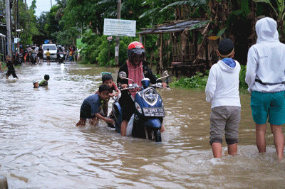 Sejumlah anak-anak bermain di tengah banjir di kawasan Jalan Nipa-nipa, Makassar, Kamis (15/2/2023).