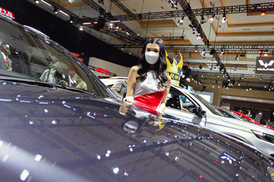 Sales promotion girl (SPG) berpose di kendaraan yang dipamerkan dalam Indonesia International Motor Show (IIMS) 2023 di JIExpo Kemayoran, Jakarta.