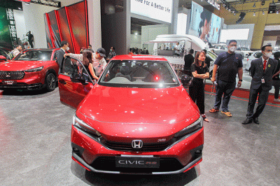 Pengunjung saat melihat mobil yang dipamerkan dalam pameran Indonesia International Motor Show (IIMS) 2023 di JIExpo Kemayoran, Jakarta, Jumat (17/2/2023).