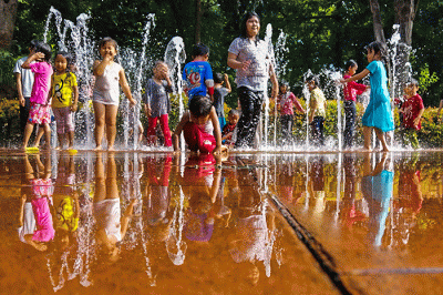 Anak-anak asik bermain air mancur di Taman Puring, Jakarta, Minggu (19/2/2023).