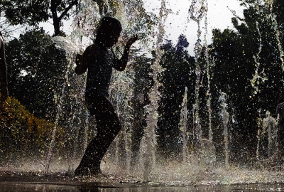 Anak-anak asik bermain air mancur di Taman Puring, Jakarta, Minggu (19/2/2023).