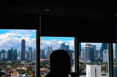 Suasana pekerja terlihat siluet berlatar belakang pemandangan Gedung-gedung perkantoran di Pusat kota Jakarta, Senin (20/2/2023).