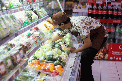 Pekerja saat merapikan buah dan sayuran yang ada di supermarket di Kawasan Joglo, Jakarta Barat, Selasa (21/2/2023).