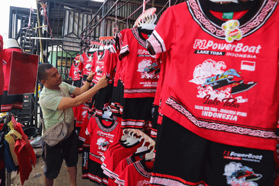 Penjual menata pernak-pernik F1 PowerBoat (F1H2O) di kawasan Danau Toba, Balige, Sumatera Utara, Jumat (24/2/2023).