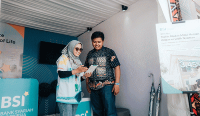 Pengunjung arena F1 PowerBoat melakukan transaksi perbankan di mobil kas keliling PT Bank Syariah Indonesia Tbk (BSI) di kawasan Danau Toba, Balige.